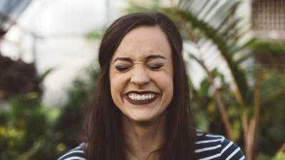 Woman smiling and closing her eyes with nature background